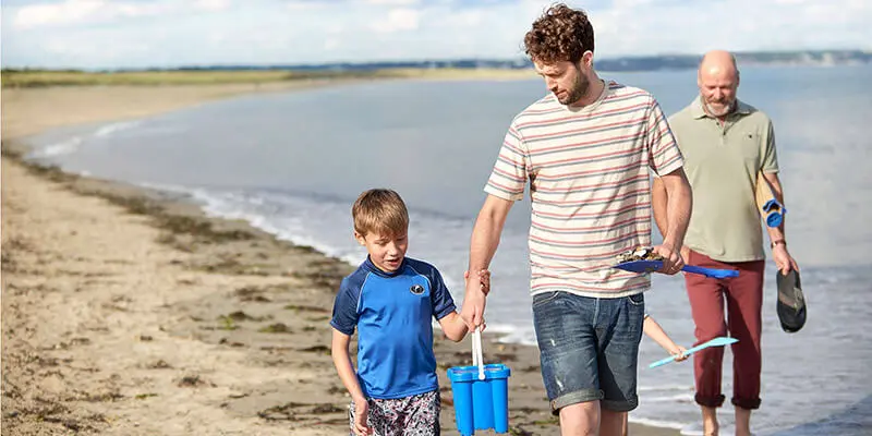 Man and child walking along the beach